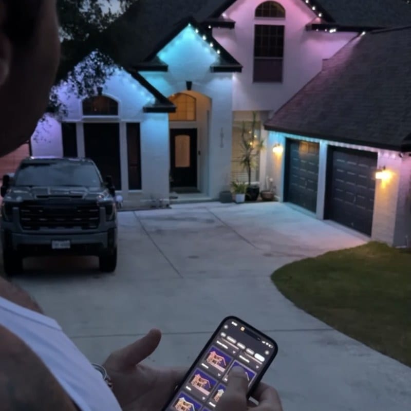 Dazzl app controlling permanent outdoor lighting on a Texas home during a free quote visit.