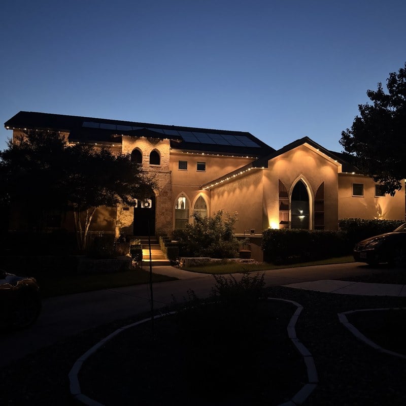 A Texas home glowing with permanent warm-white roofline lighting at twilight, controlled from the Dazzl app.