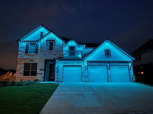 Texas Hill Country home with aqua teal cool glow LED lighting at twilight
